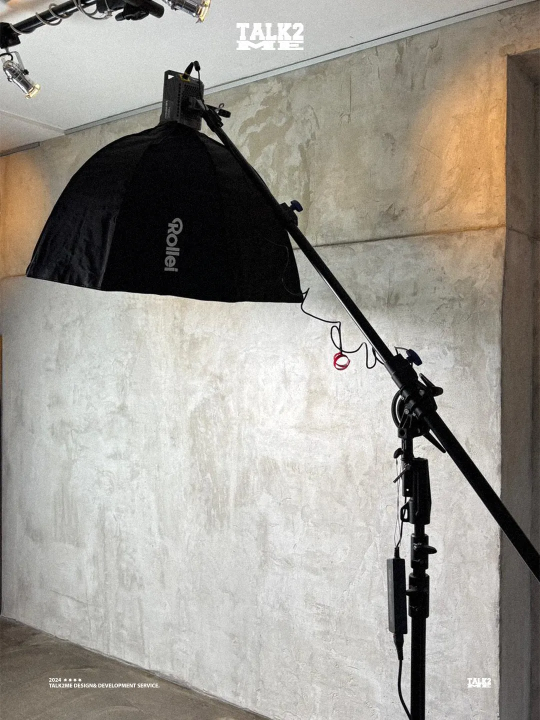 Content-Talks-Studio: Rollei-Softbox an einem Boom-Stativ vor Betonwand.